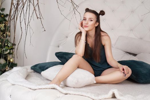 Portrait of a beautiful girl in a peignoir. Beautiful sexy lady on the bed in her bedroom. Fashion model indoors. Female underwear. Happy morning