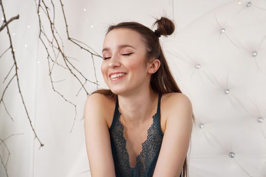 Portrait of a beautiful girl in a peignoir. Beautiful sexy lady on the bed in her bedroom. Fashion model indoors. Female underwear. Happy morning