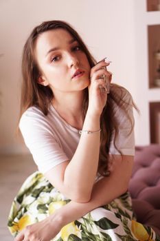 Beautiful young woman with bottle of perfume at home - pink dressing room