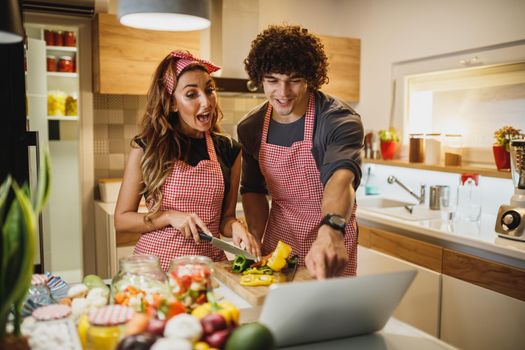 A beautiful cheerful couple trying out a new recipe in the kitchen together.