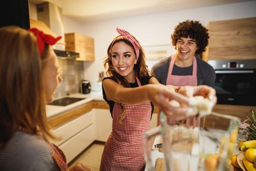 A cheerful parents spending quality time in kitchen at home with theirs cute daughter.