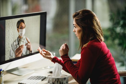 Shot of a young woman having a online consultation with a her doctor on a computer.