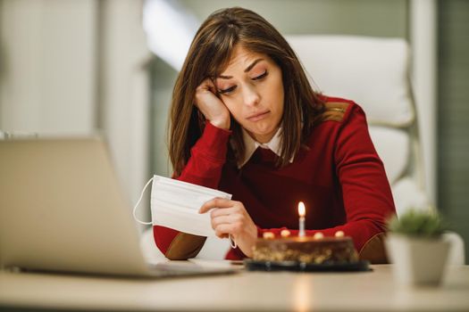Depression woman celebrating birthday alone at home during Covid-19 isolation.