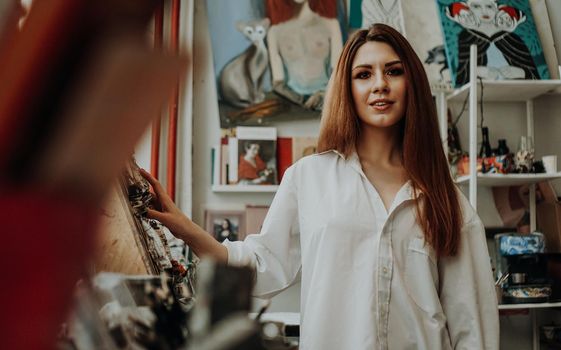 Portrait of female artist with brush in art workshop