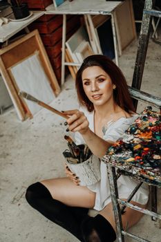 Female artist hand holding paintbrush at art workshop