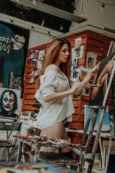 Portrait of female artist with brush in art workshop