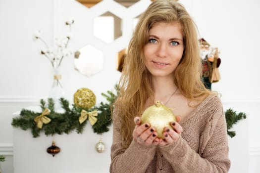 Beautiful young woman decorating a Christmas tree - soft colors preset