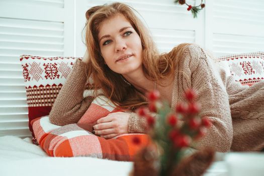 Morning, leisure, christmas, winter and people concept - happy young woman in bed at home bedroom