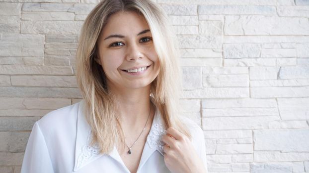 Portrait of attractive young european businesswoman on brick wall background. Success concept