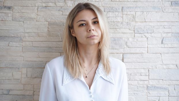 Portrait of attractive young european businesswoman on brick wall background. Leadership and leader concept