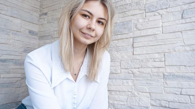 Portrait of attractive young european businesswoman on brick wall background. Success concept