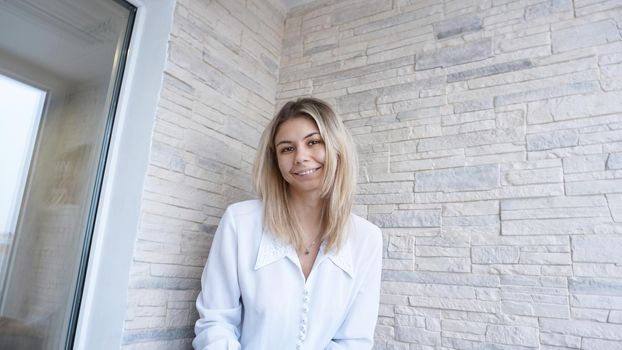 Portrait of attractive young european businesswoman on brick wall background. Success concept