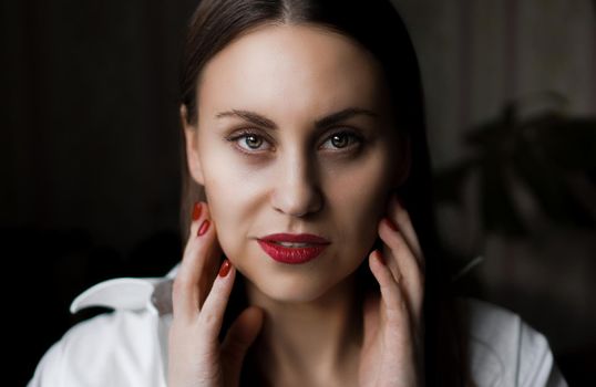 Beautiful woman with long brown straight hairs and red nails Natural home portrait