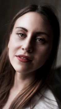 Portrait of attractive brunette woman. Home portrait of a woman with red lips in a white shirt