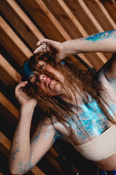 Portrait of beautiful woman with blue sparkles on her face. The concept of freaks and aliens. People are different from others. Individuality