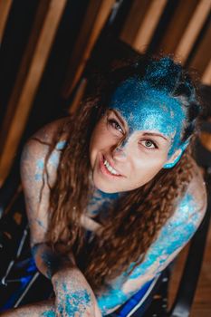 Portrait of beautiful woman with blue sparkles on her face. The concept of freaks and aliens. People are different from others. Individuality