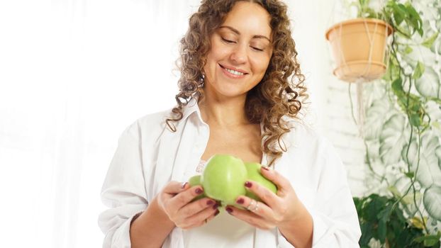 Senior happy woman with curly hair with green apples. Diet. Healthy lifestyle.