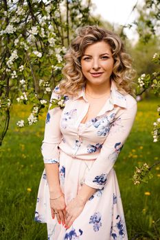 Beautiful young woman in apple garden in spring sunny day - happy moments