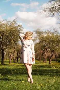 Beautiful young girl in the park in the spring. Portrait in full height. vertical photo