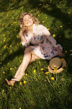 Female portrait outdoors. Woman with a straw hat in a flower field. Summer in the country