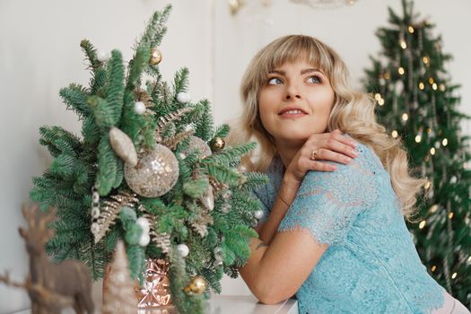 Charming Girl with Beautiful Make-up on Face in gold and white interior. Christmas Holidays, Merry Celebration with the Family