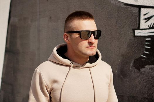 Hipster man in the street in summer day. Young man in sunglasses. Lifestyle photo