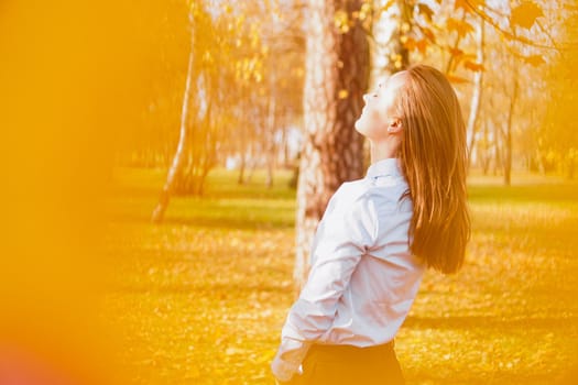 Portrait of beautiful young woman in autumn park - sunny day