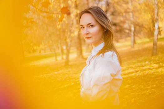 Portrait of beautiful young woman in autumn park - sunny day