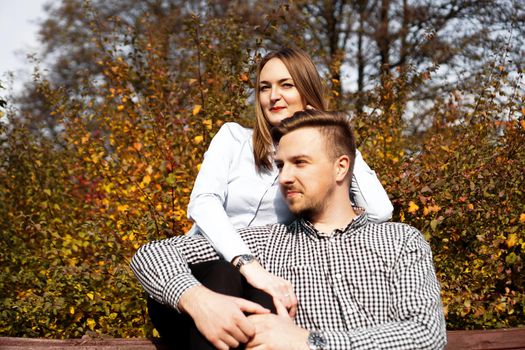Romantic couple in the autumn park - sunny day - love, relationship and dating concept