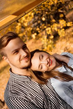 Romantic couple in the autumn park - sunny day - love, relationship and dating concept