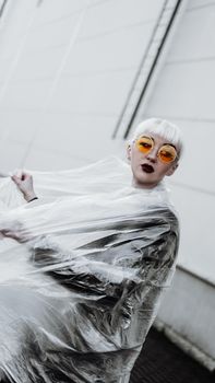 Ecology concept. Girl with plastic wrap. City Style. Urban photo