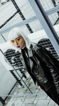 Portrait of woman with white hair and glasses. Modern urban style - vertical photo