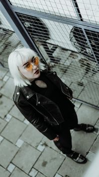 Portrait of woman with white hair and glasses. Modern urban style - vertical photo