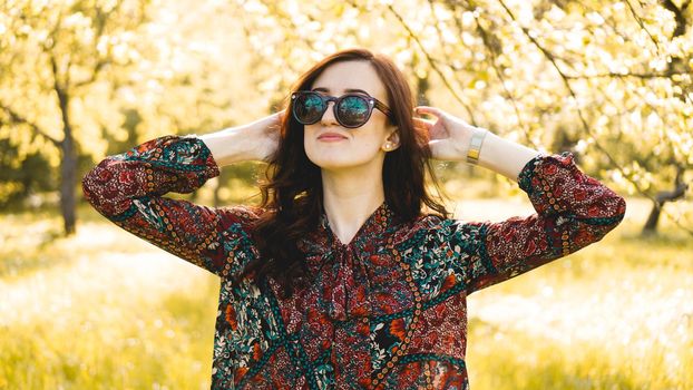 Smiling summer woman with sunglasses. Beautiful Young Woman Outdoor. Enjoy Nature. Healthy Smiling Girl in the Spring Park. Sunny day