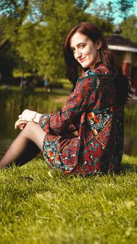 Portrait of woman in profile resting on the nature near the river. Sunny simmer day