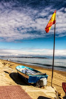 Fishing boats on the shore under spanish flag in the morning