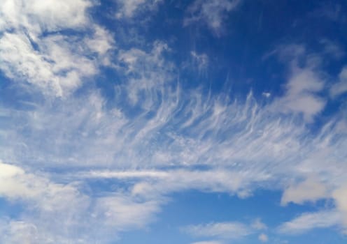 Endless blue sky with feathery white clouds.