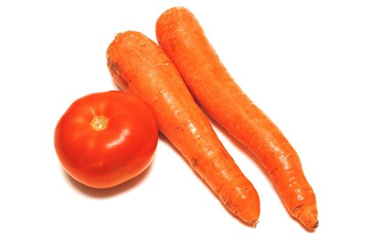 Red tomato and two carrots close up, isolated on white background