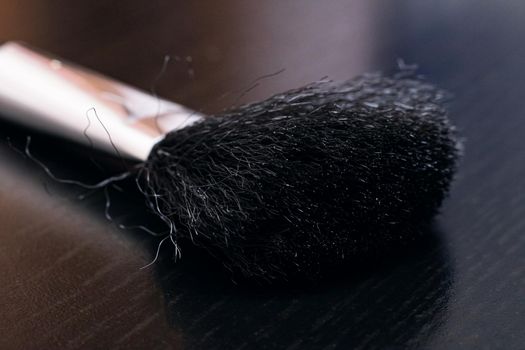 Brush for applying blush, makeup accessories on a dark background