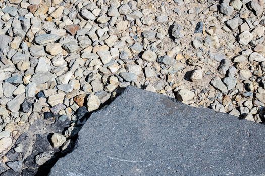 Stones and a piece of asphalt on a footpath close-up, background or texture