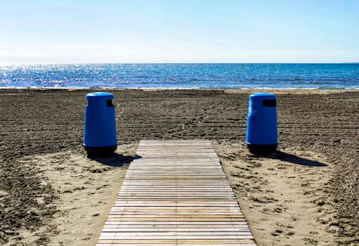 Wastebaskets and walkway to the beach in the morning