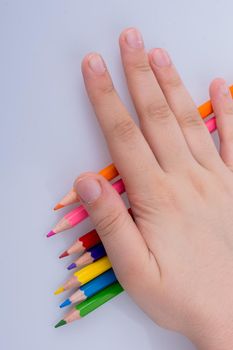 Hand holding color Pencils placed on a white background