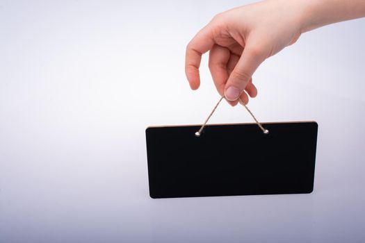 Rectangular shaped black notice board in hand on white background