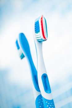 blue toothbrush with red stripe toothpaste