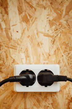 AC power plug and socket, wooden osb wall background