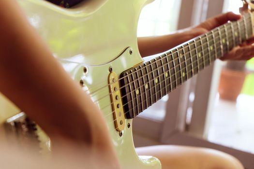 Woman hands playing electric guitar close up