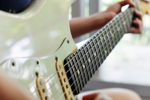 Woman hands playing electric guitar close up