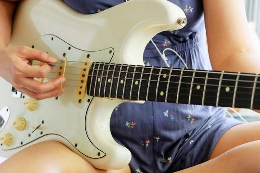 Woman hands playing electric guitar close up