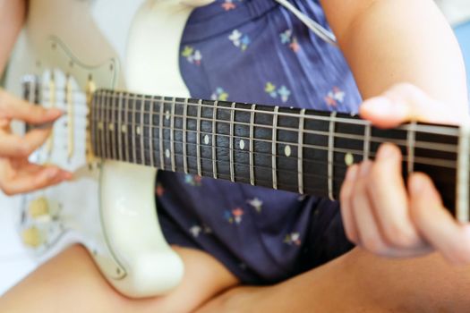 Woman hands playing electric guitar close up