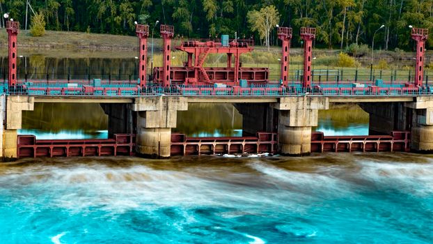 River, dam, bridge. Car and pedestrian bridge in the morning. A full-flowing river with a strong current. Clean, bubbling, fresh water.Technical construction on the river, fresh water reserves